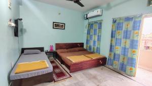 普里KaKaRa BEACH homestay的有两张床和一扇窗户的卧室