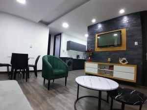 a living room with a tv and a table and chairs at Suite de 4 camas cerca de UTPL y centro in Loja