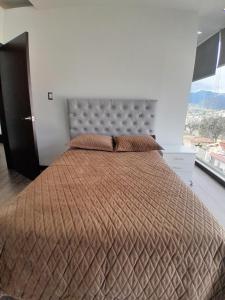 a bedroom with a large bed with a large window at Suite de 4 camas cerca de UTPL y centro in Loja