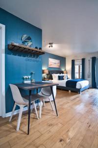 a bedroom with a bed and a table and chairs at Condo Hôtel Magog Orford in Orford