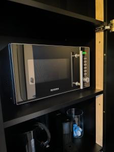 a microwave oven on a shelf in a kitchen at Studio am Waldrand in Bad Hersfeld