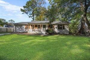 ein kleines weißes Haus mit einem großen Hof in der Unterkunft Peace at the Creek in Goose Creek