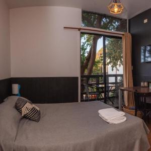 a bedroom with a bed and a large window at Abanico Suites con Kitchenette y Parking in Maitencillo +12 photos