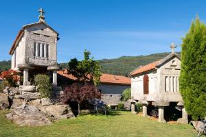 an old church with a cross on the side of it at Casa do Americano in Vilaboa