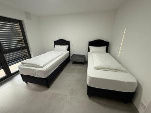two twin beds in a room with a window at Ferienwohnung am Schloss in Erbach