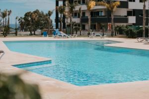 a swimming pool with blue water in a resort at Casa Madie - Sea view in Orihuela Costa