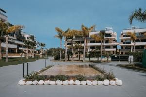 a park in front of a building with palm trees at Casa Madie - Sea view in Orihuela Costa
