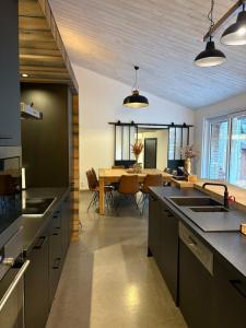 a kitchen with black counters and a dining room at Le Gîte des Platanes in Spa