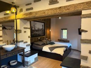 a bedroom with a large bed and a sink at Le Gîte des Platanes in Spa