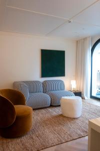 a living room with a couch and two chairs at Hotel Montaigne in Ostend