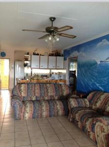 a living room with couches and a ceiling fan at Andante Villas in Kingsburgh