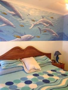 a bedroom with a mural of dolphins on the wall at Andante Villas in Kingsburgh
