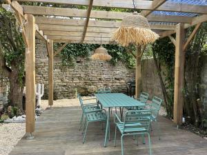 a picnic table and chairs under a wooden pergola at La Playita - 4 chambres - Plage in Le Château-dʼOléron