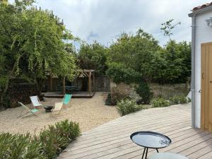 a patio with chairs and a table on a wooden deck at La Playita - 4 chambres - Plage in Le Château-dʼOléron +13 photos