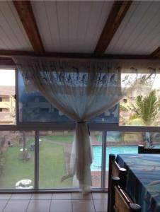 a window with a curtain in a room with a pool at Andante Villas in Kingsburgh