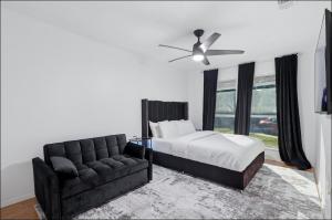 a bedroom with a bed and a couch and a ceiling fan at Homes in Prosper in Prosper +47 photos