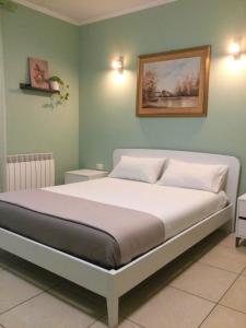 een slaapkamer met een groot bed met groene muren bij Sunny House Fourteen in Assemini