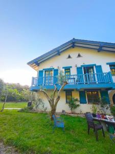 a house with blue balconies and a table and chairs at Gurbialde Etxea in Mutriku