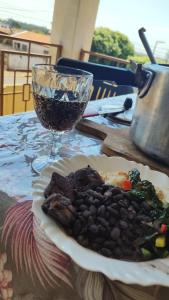 een bord eten op tafel met een wijnglas bij POUSADA ELSHADAY Centro in Osvaldo Cruz +13 foto's