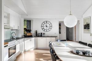 a kitchen with a table and a clock on the wall at 2502-Nexo-Gubbegardsvejen-31 in Neksø