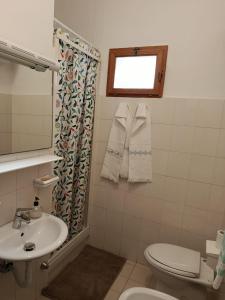 a bathroom with a sink and a toilet and a window at La Villetta in Vittorito