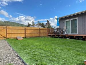 a backyard with a fence and a table and chairs at Mountain view, 5-bedroom home with sauna in Oakridge +26 photos