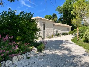 a stone house with a garden and a driveway at Domaine d Arcadie in Montaigu-de-Quercy