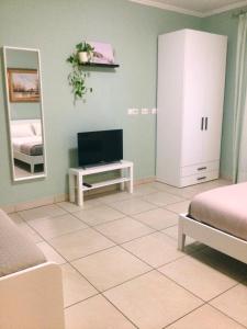 een woonkamer met een tv en een spiegel bij Sunny House Fourteen in Assemini +24 foto's