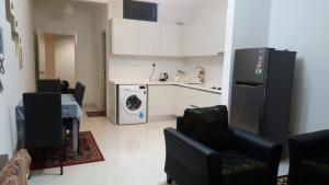 a kitchen with a refrigerator and a washing machine at SKS Pavillion Residences in Johor Bahru