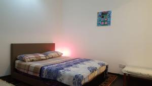 une chambre avec un lit avec une lumière sur le mur dans l'établissement SKS Pavillion Residences, à Johor Bahru 71 autres photos