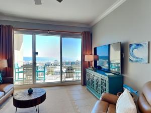 ein Wohnzimmer mit einem TV und einem Balkon in der Unterkunft The Indies #703 in Fort Morgan