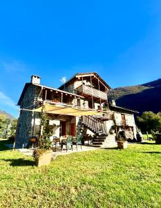 a building with a table and chairs in front of it at Chalet Valchiavenna in San Cassiano