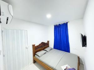 库库塔Hotel 7的卧室里有一张带蓝色窗帘的床