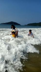 two people playing in the water on the beach at Mystique Copper Smart Villa in Sadāshivgarh