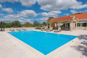 a swimming pool with chairs and a gazebo at Rural Villa Olive Krka- 4 bedrooms, 3 bathrooms, private pool, park Krka 10 min in Ljubotić