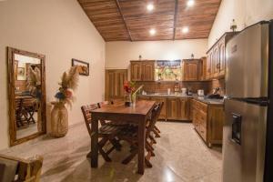 a kitchen with a wooden table and a refrigerator at Promisedland Tayrona Cabins Hotel in Buritaca +99 photos