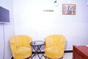 2 sillas amarillas y una mesa en una habitación en M3 Stella Hotel, en Kampala
