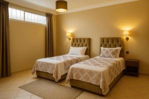 a bedroom with two beds and a window at Luxury apartment with garden view in Agadir