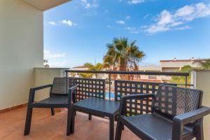 Dos sillas y una mesa en un balcón. en Obsidian Peridotita Adeje, en Adeje