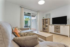 Una sala de estar con un sofá y un televisor de pantalla plana. en Obsidian Peridotita Adeje, en Adeje