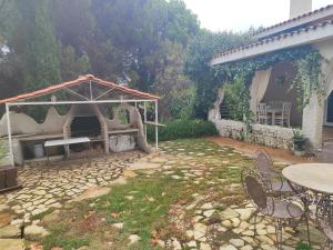a backyard with a grill and a table and chairs at La Cubertilla en Madrid in Navas del Rey