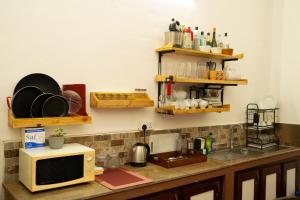 un comptoir de cuisine avec un micro-ondes et quelques étagères dans l'établissement Altura Villa Galle, à Galle 40 autres photos
