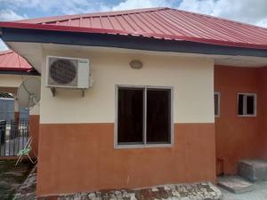 una pequeña casa con techo rojo en Richbee Hotel and Suites, en Abuja