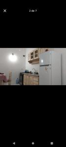 eine Küche mit weißem Kühlschrank und Holzschränken in der Unterkunft Casa mar del tuyu in Mar del Tuyú