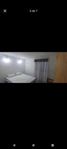 a small bedroom with a bed and a window at Casa mar del tuyu in Mar del Tuyú