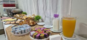 una mesa con aperitivos y un vaso de zumo de naranja en Pousada Apatej, en Peruíbe 7 fotos más