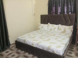 Una cama con sábanas blancas y almohadas en una habitación. en Richbee Hotel and Suites, en Abuja 16 fotos más