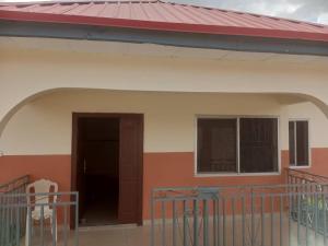 una pequeña casa con techo rojo en Richbee Hotel and Suites, en Abuja