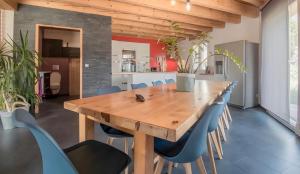 a dining room with a wooden table and blue chairs at Chalet d'Aussois Lerovi in Aussois