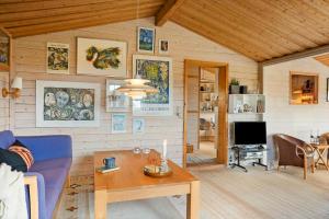 een woonkamer met een blauwe bank en een tafel bij 1069-Thisted-Kobbelsti-23 in Klitmøller